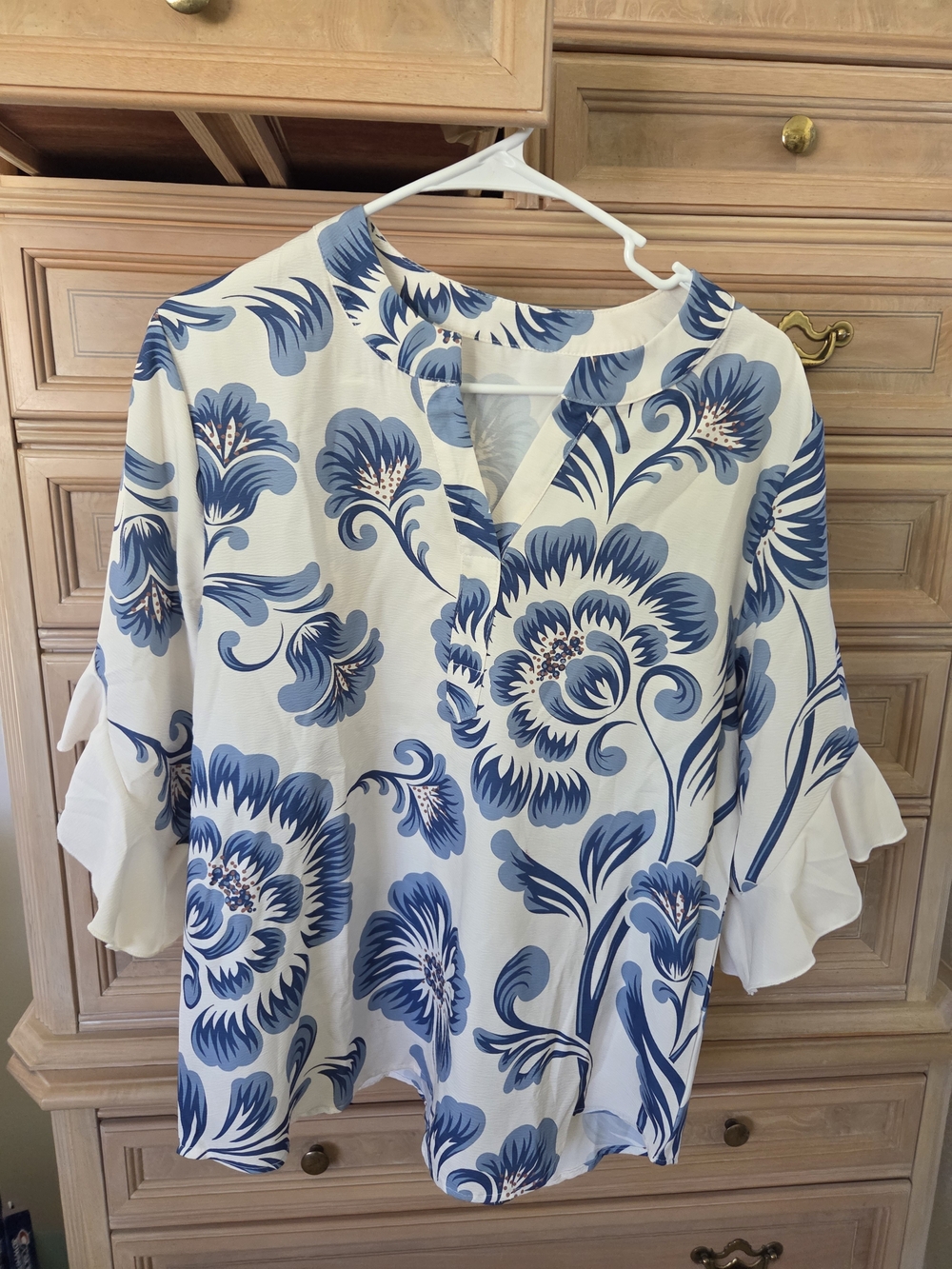 NEW WHITE AND BLUE FLORAL TUNIC WITH SPLIT NECKLINE AND SOFT RUFFLED SLEEVES.